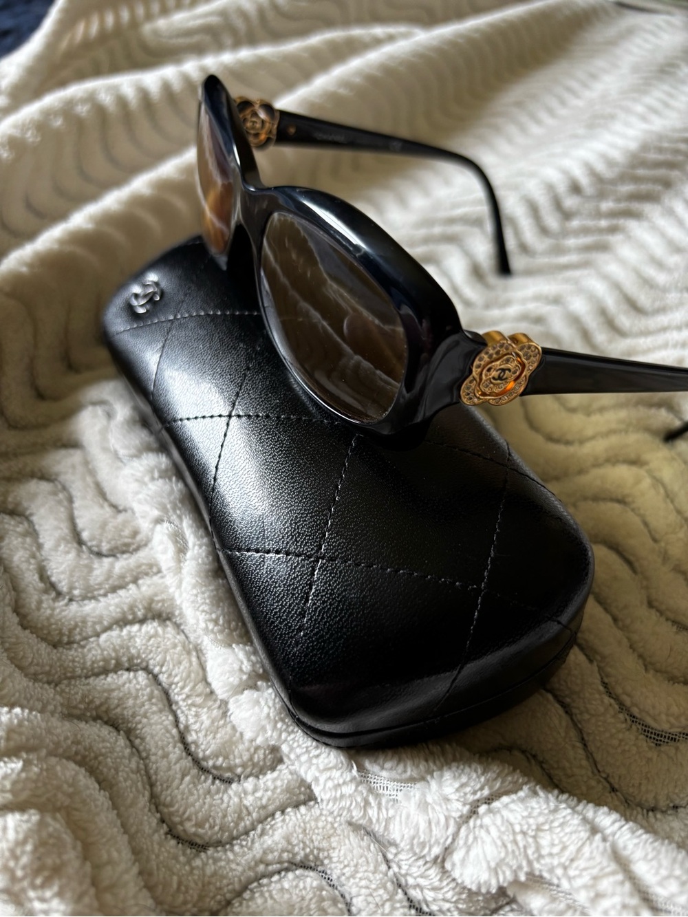 CHANEL Black Oval Sunglasses with Gold Camellia Emblem